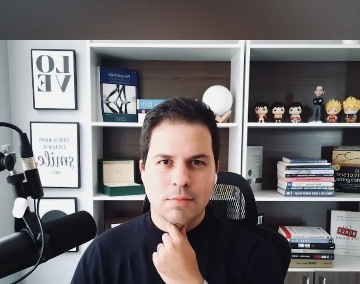 Juan Daniel Lomba en su espacio de consulta online, con micrófono y estantería de libros